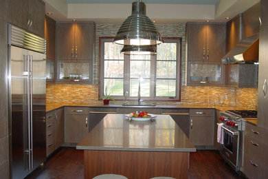 Example of a mid-sized trendy dark wood floor kitchen design in Nashville with flat-panel cabinets, light wood cabinets, solid surface countertops, multicolored backsplash, matchstick tile backsplash and stainless steel appliances