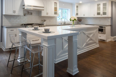 Example of a large transitional l-shaped dark wood floor and brown floor eat-in kitchen design in Philadelphia with an undermount sink, beaded inset cabinets, white cabinets, quartz countertops, white backsplash, ceramic backsplash, stainless steel appliances, an island and white countertops