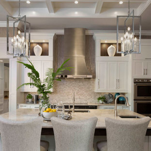 Mediterranean kitchen ideas - Tuscan dark wood floor and brown floor kitchen photo in Miami with an undermount sink, shaker cabinets, white cabinets, beige backsplash, stainless steel appliances, an island and beige countertops