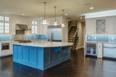 Trendy l-shaped kitchen photo in Other with a farmhouse sink, shaker cabinets, quartz countertops, blue backsplash, stainless steel appliances and an island