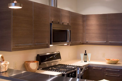 Bild på ett litet funkis kök, med släta luckor, skåp i mellenmörkt trä, beige stänkskydd, stänkskydd i keramik, rostfria vitvaror, en halv köksö, en undermonterad diskho och bänkskiva i kvarts