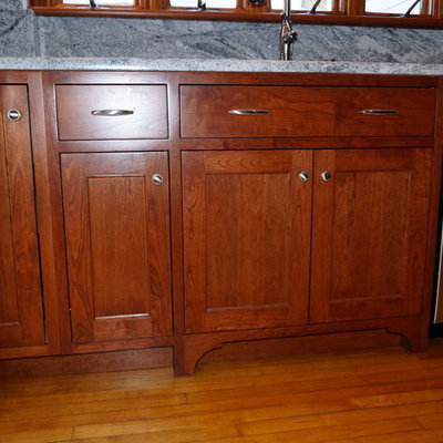 Inspiration for a craftsman l-shaped light wood floor kitchen pantry remodel in Boston with an undermount sink, shaker cabinets, medium tone wood cabinets, wood countertops, gray backsplash, stone slab backsplash, stainless steel appliances and an island