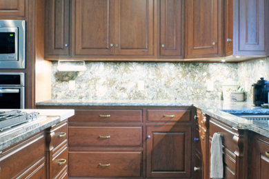 Example of a large classic l-shaped vinyl floor and gray floor open concept kitchen design in New York with an undermount sink, raised-panel cabinets, medium tone wood cabinets, quartz countertops, multicolored backsplash, quartz backsplash, stainless steel appliances, an island and multicolored countertops