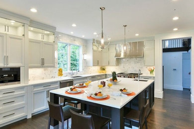 Open concept kitchen - mid-sized transitional l-shaped dark wood floor and brown floor open concept kitchen idea in New York with an undermount sink, recessed-panel cabinets, gray cabinets, stone tile backsplash, stainless steel appliances, an island, quartz countertops and white backsplash