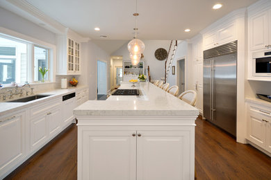 Inspiration for a mid-sized transitional galley medium tone wood floor kitchen pantry remodel in New York with a farmhouse sink, white cabinets, white backsplash, stainless steel appliances and an island