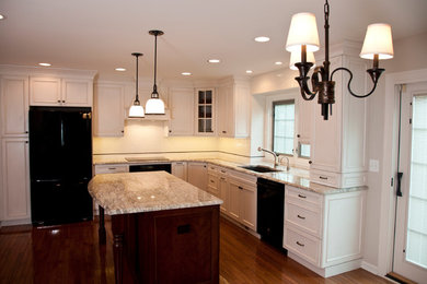 Eat-in kitchen - mid-sized transitional u-shaped medium tone wood floor eat-in kitchen idea in Detroit with an undermount sink, recessed-panel cabinets, white cabinets, granite countertops, white backsplash, ceramic backsplash, black appliances and an island