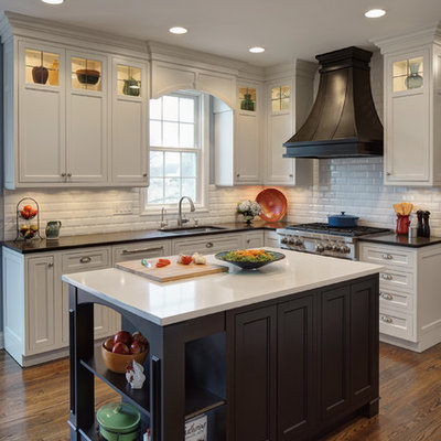 Inspiration for a mid-sized timeless l-shaped dark wood floor kitchen remodel in Chicago with an undermount sink, beaded inset cabinets, white cabinets, granite countertops, white backsplash, subway tile backsplash, stainless steel appliances, an island and multicolored countertops