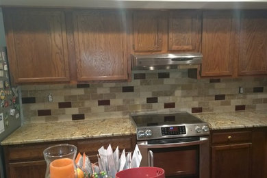 Inspiration for a kitchen remodel in Baltimore with an undermount sink, raised-panel cabinets, dark wood cabinets, granite countertops, beige backsplash and stainless steel appliances