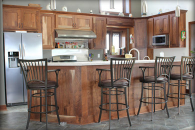 Example of a mid-sized l-shaped slate floor enclosed kitchen design in Cedar Rapids with shaker cabinets, white cabinets, quartz countertops, stainless steel appliances and an island