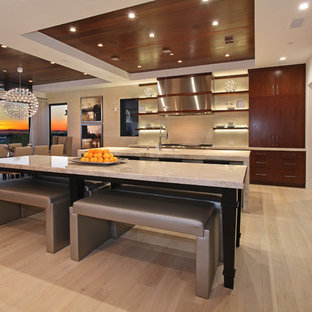Large contemporary l-shaped eat-in kitchen in Orange County with flat-panel cabinets, dark wood cabinets, limestone benchtops, with island, an undermount sink, beige splashback, stainless steel appliances, light hardwood floors, ceramic splashback and brown floor.