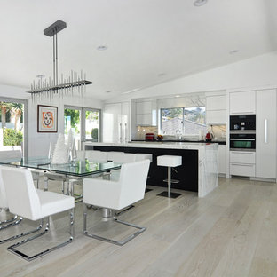 Immagine di una grande cucina design con lavello sottopiano, ante lisce, ante bianche, top in marmo, paraspruzzi bianco, elettrodomestici in acciaio inossidabile, parquet chiaro, isola, paraspruzzi in marmo e pavimento marrone