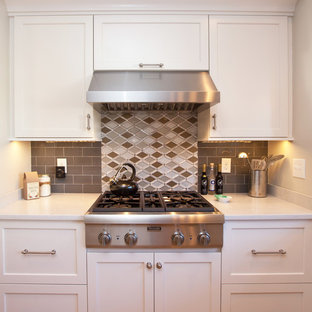 Esempio di una cucina chic di medie dimensioni con lavello stile country, ante con bugna sagomata, ante bianche, top in quarzo composito, paraspruzzi grigio, paraspruzzi con piastrelle di vetro, elettrodomestici in acciaio inossidabile e pavimento in legno massello medio