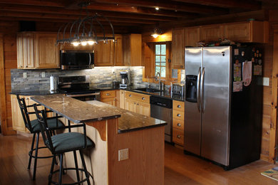Mid-sized mountain style l-shaped light wood floor eat-in kitchen photo in Kansas City with an undermount sink, raised-panel cabinets, light wood cabinets, granite countertops, gray backsplash, slate backsplash, stainless steel appliances and an island