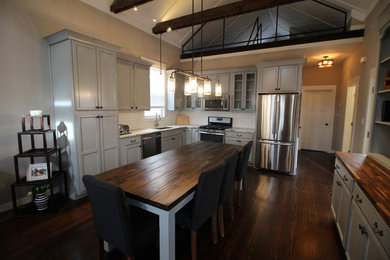 Small transitional l-shaped dark wood floor eat-in kitchen photo in St Louis with an undermount sink, recessed-panel cabinets, gray cabinets, marble countertops, white backsplash, subway tile backsplash and stainless steel appliances