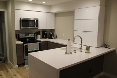 Idéer för att renovera ett litet funkis vit vitt kök, med en undermonterad diskho, släta luckor, vita skåp, bänkskiva i kvarts, rostfria vitvaror, vinylgolv och en halv köksö