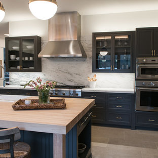 Inspiration pour une grand cuisine américaine traditionnelle en L avec un évier posé, un placard à porte affleurante, des portes de placard grises, un plan de travail en marbre, une crédence blanche, un sol en calcaire, un îlot central, un sol beige, une crédence en dalle de pierre et un électroménager en acier inoxydable.