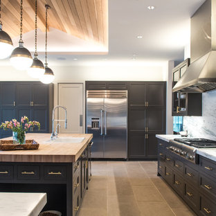 Idee per una grande cucina chic con lavello da incasso, elettrodomestici in acciaio inossidabile, ante grigie, top in marmo, paraspruzzi bianco, paraspruzzi in lastra di pietra, pavimento in pietra calcarea, pavimento beige e ante in stile shaker