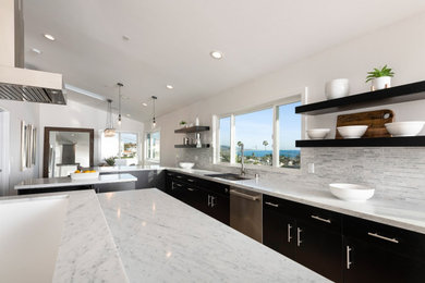 Inspiration for a mid-sized contemporary u-shaped medium tone wood floor and beige floor open concept kitchen remodel in Orange County with a single-bowl sink, flat-panel cabinets, black cabinets, marble countertops, white backsplash, stone tile backsplash, stainless steel appliances, an island and white countertops