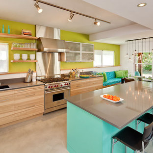 Foto di una cucina abitabile minimal con elettrodomestici in acciaio inossidabile, nessun'anta, lavello a vasca singola, ante in legno scuro e top in quarzo composito