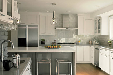 Example of a large minimalist u-shaped kitchen pantry design in San Francisco with recessed-panel cabinets, white cabinets, solid surface countertops and an island