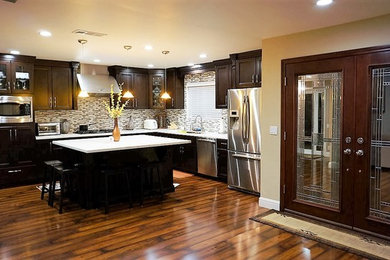 Mid-sized transitional l-shaped dark wood floor eat-in kitchen photo in Orange County with dark wood cabinets, multicolored backsplash, mosaic tile backsplash, stainless steel appliances and an island