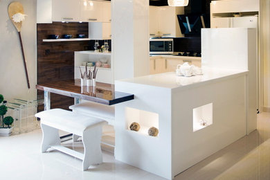 Example of a mid-sized minimalist l-shaped ceramic tile eat-in kitchen design in Other with a double-bowl sink, flat-panel cabinets, white cabinets, solid surface countertops, brown backsplash, ceramic backsplash, white appliances and an island