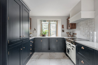 Design ideas for a medium sized traditional u-shaped kitchen in Devon with shaker cabinets, blue cabinets, composite countertops, limestone flooring, no island, white worktops, white appliances and grey floors.
