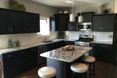 Example of a mid-sized trendy u-shaped dark wood floor eat-in kitchen design in Omaha with a farmhouse sink, shaker cabinets, dark wood cabinets, granite countertops, white backsplash, ceramic backsplash, stainless steel appliances and an island