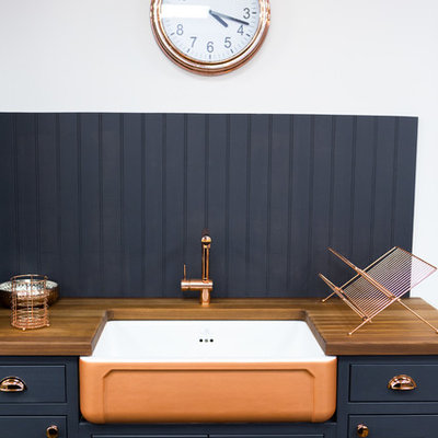 Example of a small transitional single-wall kitchen design in Essex with shaker cabinets, wood countertops, wood backsplash, a farmhouse sink, blue cabinets, blue backsplash and brown countertops