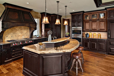Example of a classic l-shaped medium tone wood floor open concept kitchen design in Minneapolis with stainless steel appliances, raised-panel cabinets, dark wood cabinets, granite countertops, brown backsplash, stone tile backsplash and an island
