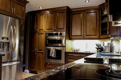 Mittelgroße Klassische Küche in U-Form mit Unterbauwaschbecken, profilierten Schrankfronten, dunklen Holzschränken, Granit-Arbeitsplatte, Küchengeräten aus Edelstahl, Porzellan-Bodenfliesen und Halbinsel in Toronto