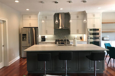 Mid-sized transitional single-wall medium tone wood floor and brown floor eat-in kitchen photo in Other with an undermount sink, shaker cabinets, white cabinets, quartzite countertops, gray backsplash, glass tile backsplash, stainless steel appliances, an island and multicolored countertops