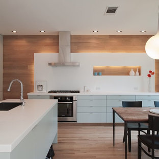 Contemporary eat-in kitchen remodeling - Eat-in kitchen - contemporary eat-in kitchen idea in Austin with stainless steel appliances, flat-panel cabinets, blue cabinets, quartz countertops, white backsplash and stone slab backsplash