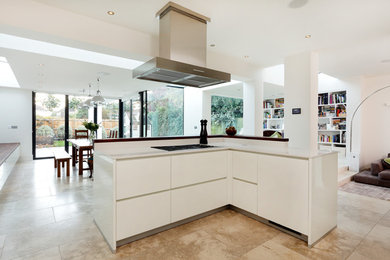 Photo of a medium sized contemporary l-shaped open plan kitchen in London with an integrated sink, flat-panel cabinets, white cabinets, composite countertops, green splashback, glass sheet splashback, stainless steel appliances, ceramic flooring and an island.