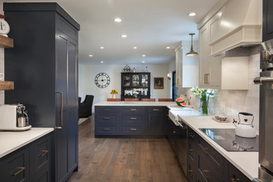 Country l-shaped medium tone wood floor eat-in kitchen photo in Denver with a farmhouse sink, shaker cabinets, blue cabinets, quartz countertops, white backsplash, ceramic backsplash, stainless steel appliances, a peninsula and white countertops