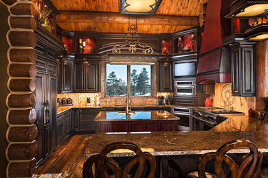 Example of a classic dark wood floor kitchen design in Denver with raised-panel cabinets, dark wood cabinets, paneled appliances and an island