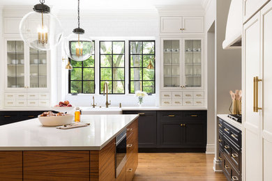 Inspiration for a mid-sized transitional light wood floor eat-in kitchen remodel in Detroit with a farmhouse sink, recessed-panel cabinets, blue cabinets, marble countertops, white backsplash, ceramic backsplash, stainless steel appliances and an island