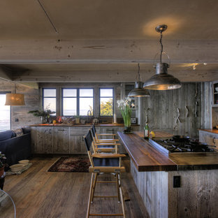 Ispirazione per una cucina ad ambiente unico rustica con ante di vetro e top in legno