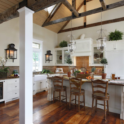 Large farmhouse l-shaped dark wood floor and brown floor kitchen photo in Philadelphia with a farmhouse sink, white cabinets, stone slab backsplash, paneled appliances, beaded inset cabinets, granite countertops, an island and brown countertops