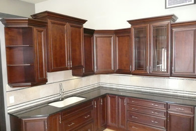 L-shaped kitchen photo in Other with raised-panel cabinets, dark wood cabinets and quartz countertops