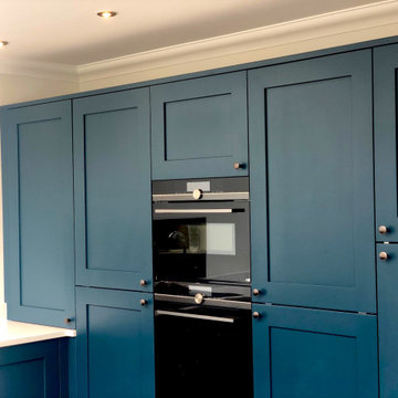 Deep blue shaker kitchen with blackened copper door knobs