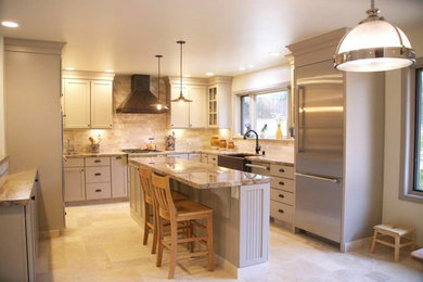 Large country u-shaped travertine floor and beige floor eat-in kitchen photo in Other with a farmhouse sink, recessed-panel cabinets, beige cabinets, granite countertops, beige backsplash, stone tile backsplash, stainless steel appliances and an island