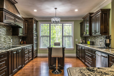 Huge elegant galley light wood floor eat-in kitchen photo in Other with a double-bowl sink, raised-panel cabinets, dark wood cabinets, granite countertops, brown backsplash, glass tile backsplash, stainless steel appliances and an island