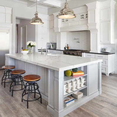 Open concept kitchen - large traditional l-shaped ceramic tile and brown floor open concept kitchen idea in Phoenix with an undermount sink, recessed-panel cabinets, white cabinets, quartz countertops, white backsplash, ceramic backsplash, stainless steel appliances and an island