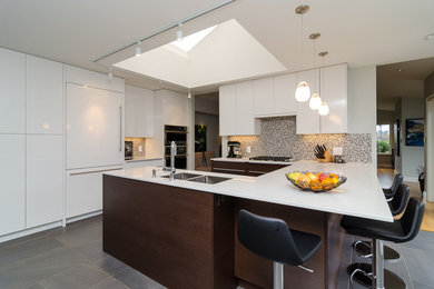 Offene Moderne Küche in U-Form mit Unterbauwaschbecken, Quarzwerkstein-Arbeitsplatte, Küchengeräten aus Edelstahl und Keramikboden in Vancouver
