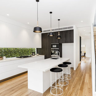 Inspiration for a contemporary kitchen in Sydney with a single-bowl sink, flat-panel cabinets, white cabinets, light hardwood floors, with island, beige floor and white benchtop.