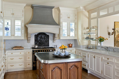 Inspiration for a mid-sized victorian u-shaped medium tone wood floor and brown floor enclosed kitchen remodel in San Francisco with an undermount sink, white cabinets, gray backsplash, black appliances, an island, raised-panel cabinets, quartz countertops and stone slab backsplash