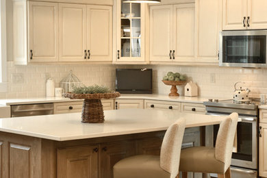 Example of a large transitional u-shaped light wood floor eat-in kitchen design in Other with a drop-in sink, flat-panel cabinets, white cabinets, laminate countertops, white backsplash, subway tile backsplash, stainless steel appliances and an island
