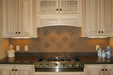Kitchen - mid-sized mediterranean kitchen idea in Other with stainless steel appliances, raised-panel cabinets, light wood cabinets, granite countertops, brown backsplash and stone tile backsplash