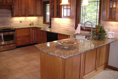 Example of a mid-sized u-shaped eat-in kitchen design in Cincinnati with glass-front cabinets, medium tone wood cabinets, granite countertops and a peninsula